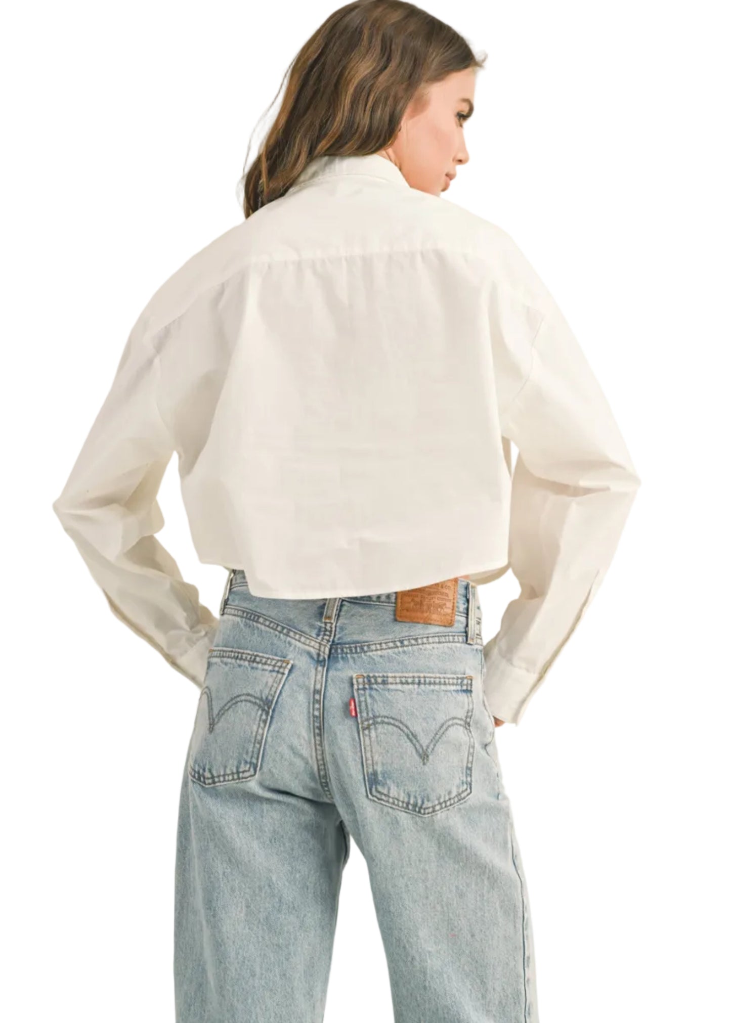 Person wearing a white shirt and light blue jeans with Levi's logo on a beige background