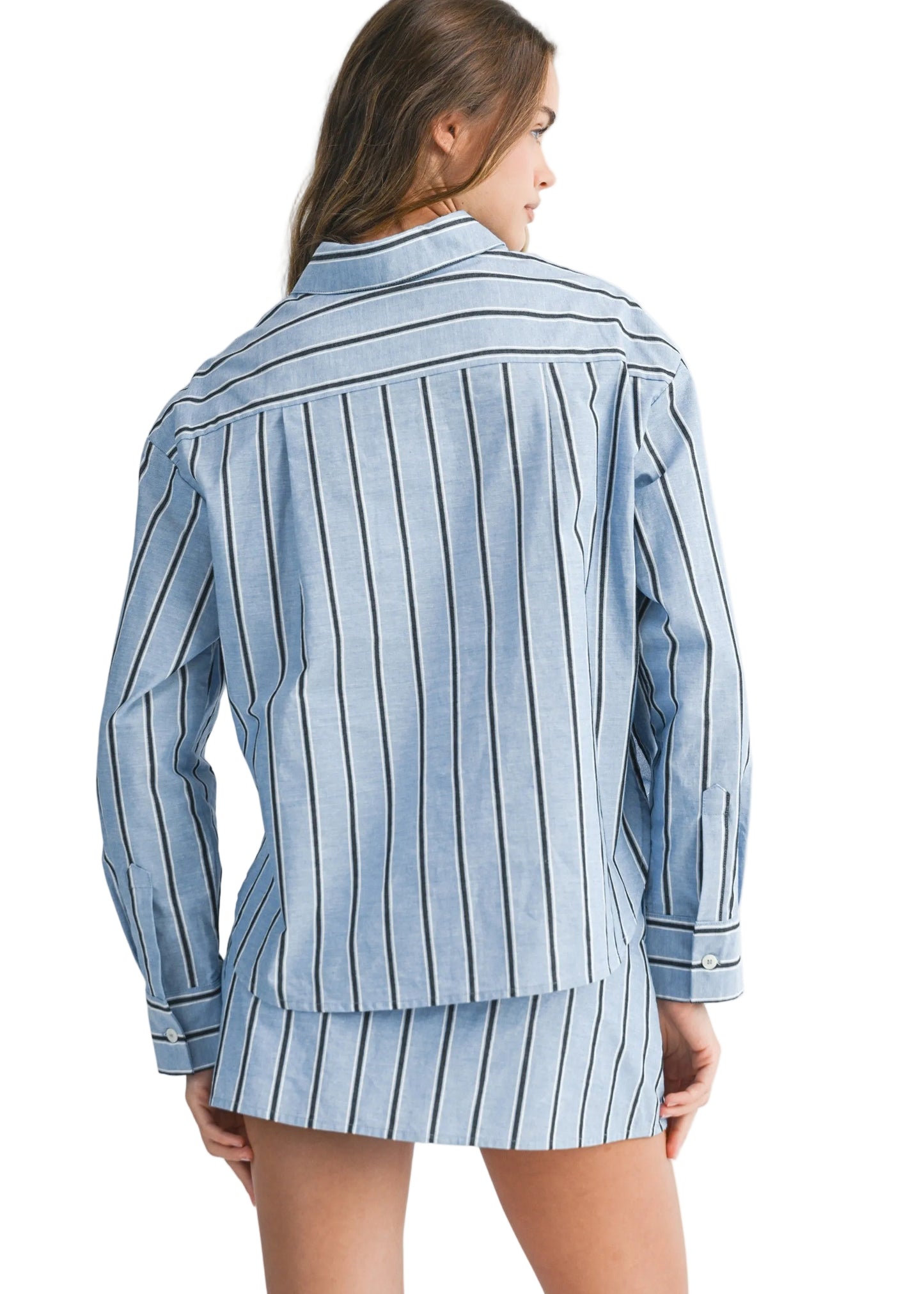 Woman wearing a blue and white striped shirt and shorts set on a plain background