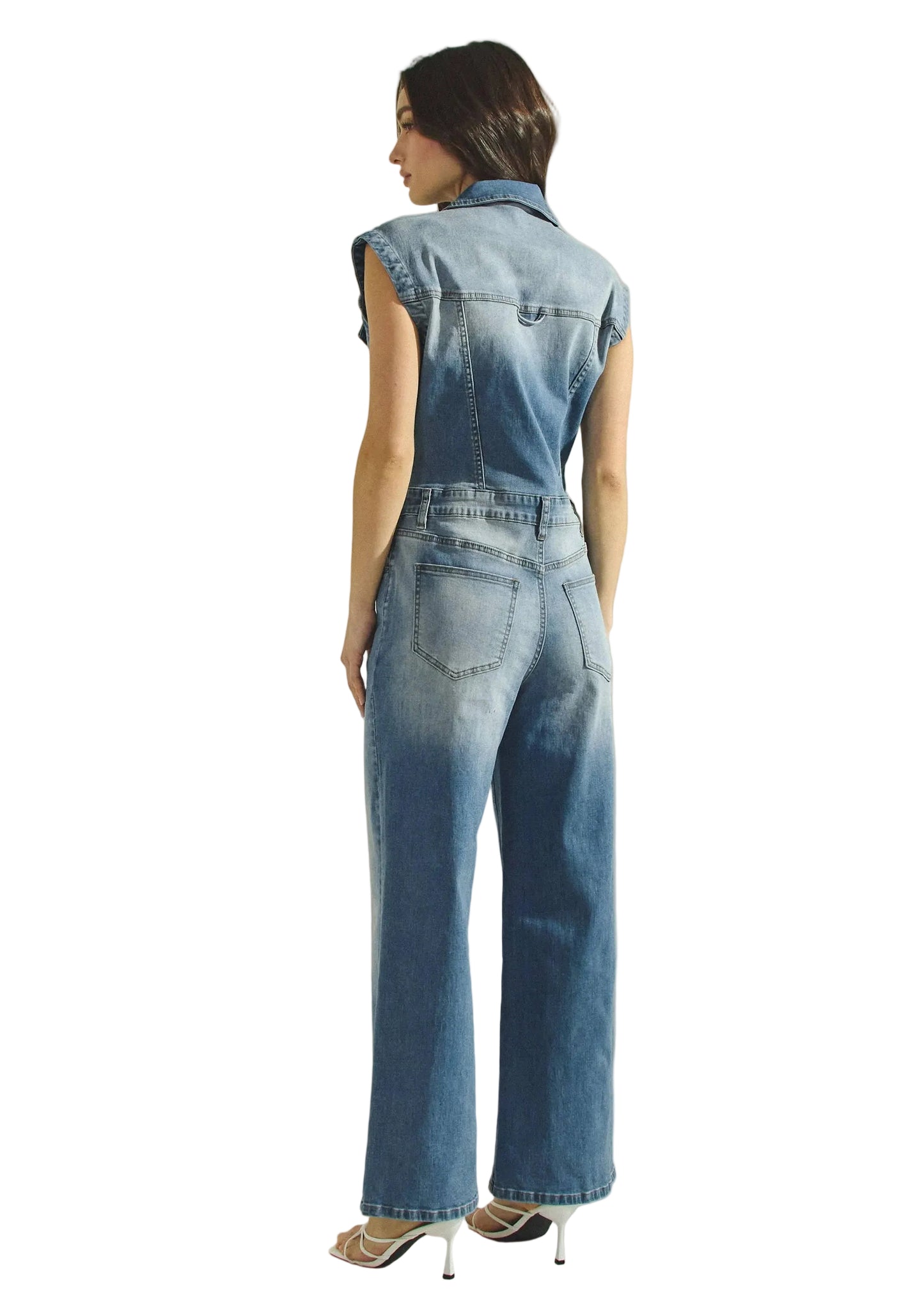 Woman wearing a denim jumpsuit on a beige background