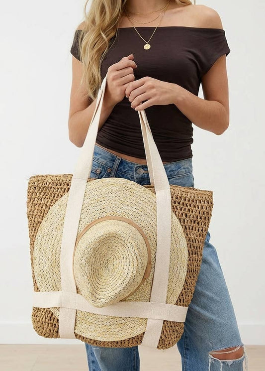 Woman holding a straw tote bag with a straw hat inside against a plain background