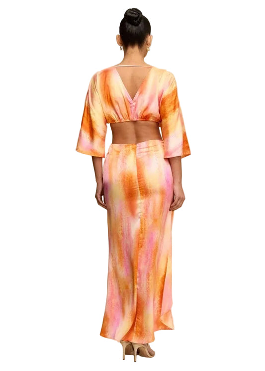 Woman wearing a colorful tie-dye outfit on a beige background