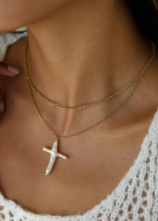 Close-up of a person wearing a gold necklace with a star-shaped pendant.