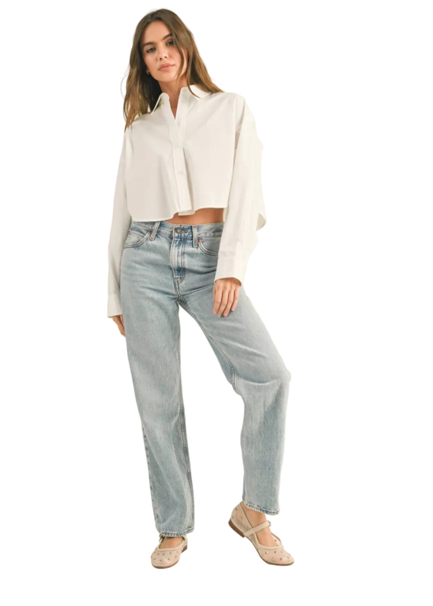 Woman wearing a white shirt and light blue jeans on a beige background