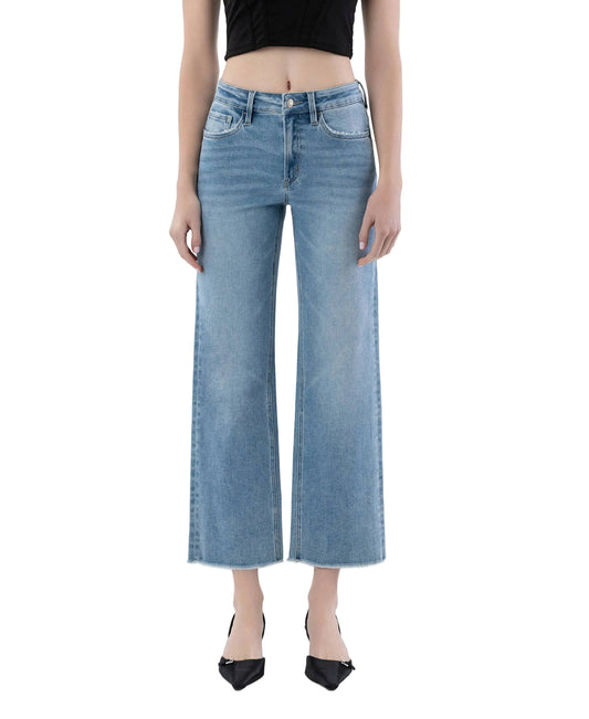 Person wearing light blue jeans on a white background