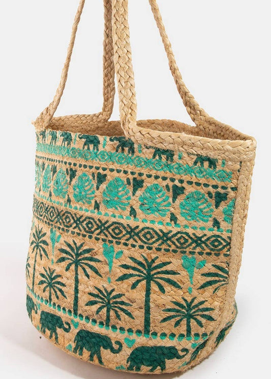 Woven bag with green elephant and palm tree pattern on a white background.