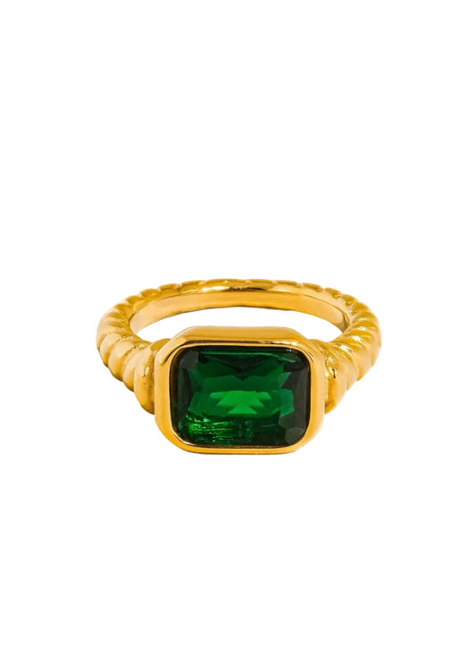 Three gold-colored cocktail rings with rectangular cut cubic zirconia stones, displayed against a white background.