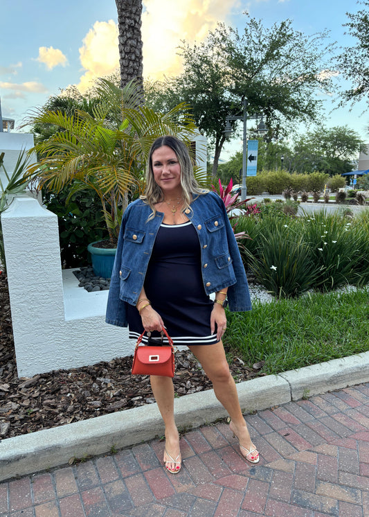 Woman standing outdoors with palm trees and a clear sky