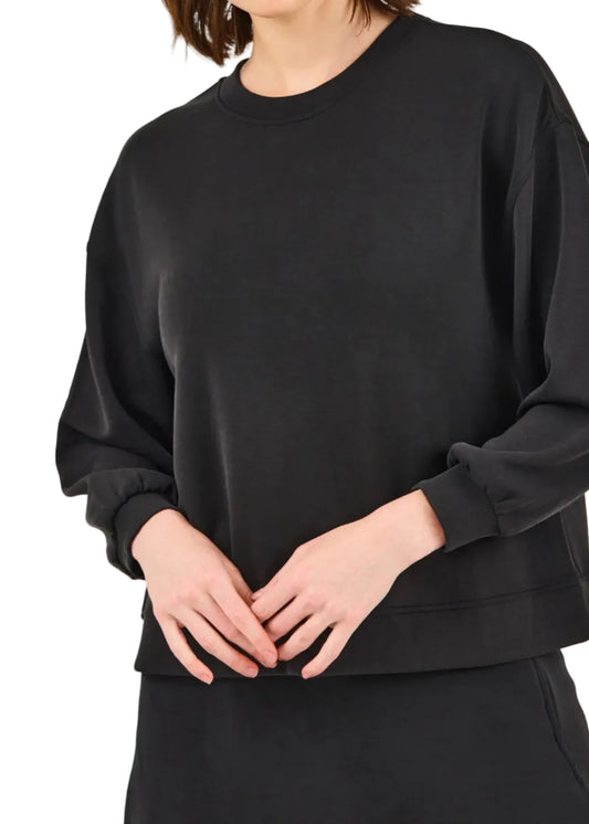 Person wearing a black oversized sweatshirt on a light gray background