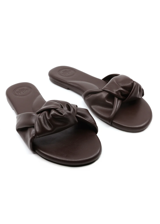 Pair of brown sandals with bow details on a white background