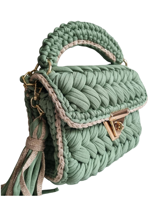 Green braided handbag with a gold clasp on a white background