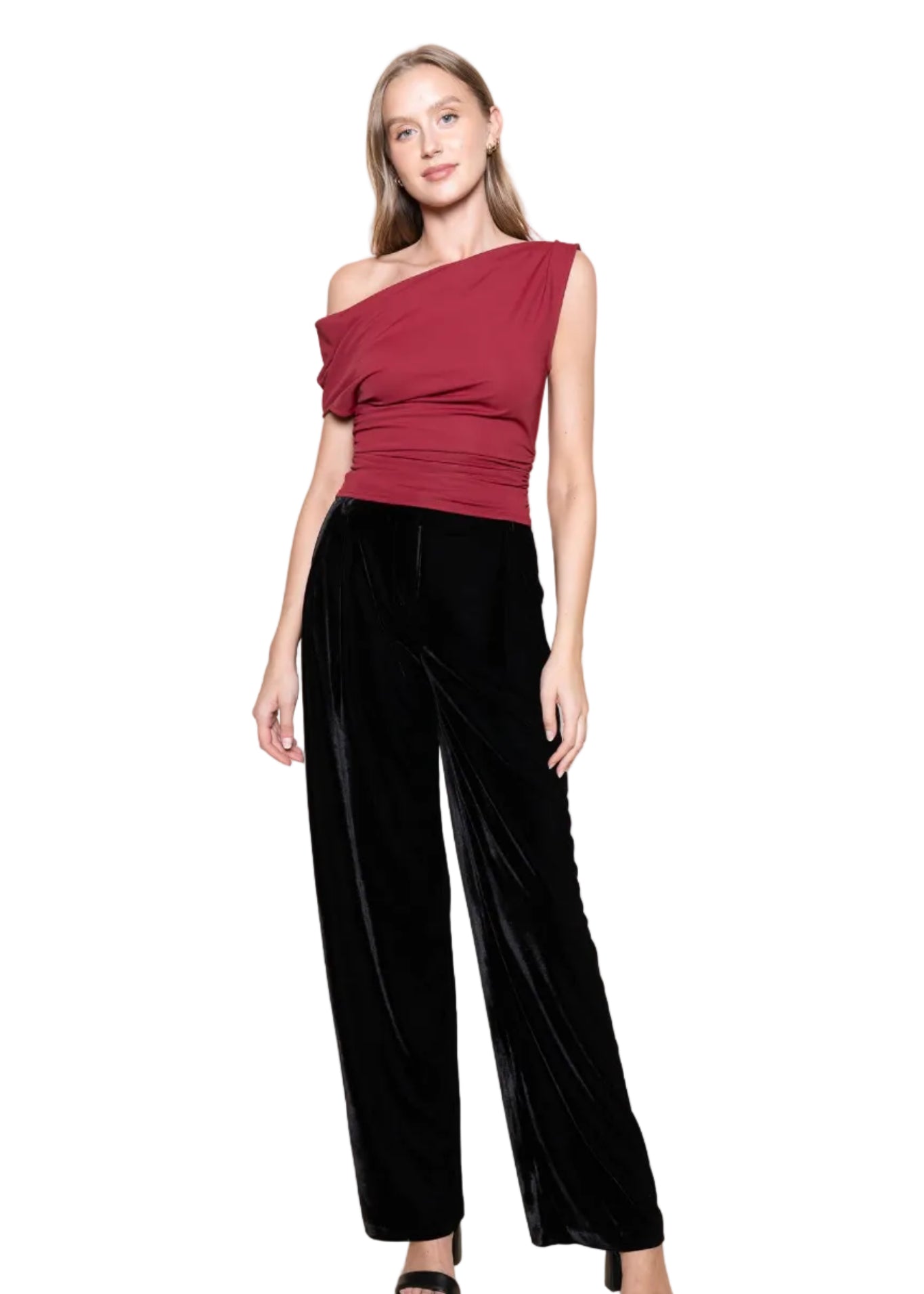 Woman wearing a one-shoulder red top and black pants on a beige background