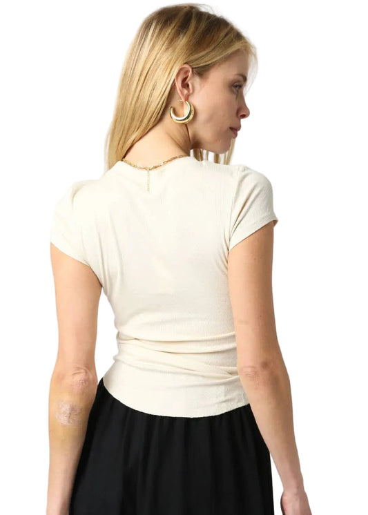 Woman wearing a white top and black skirt on a plain background