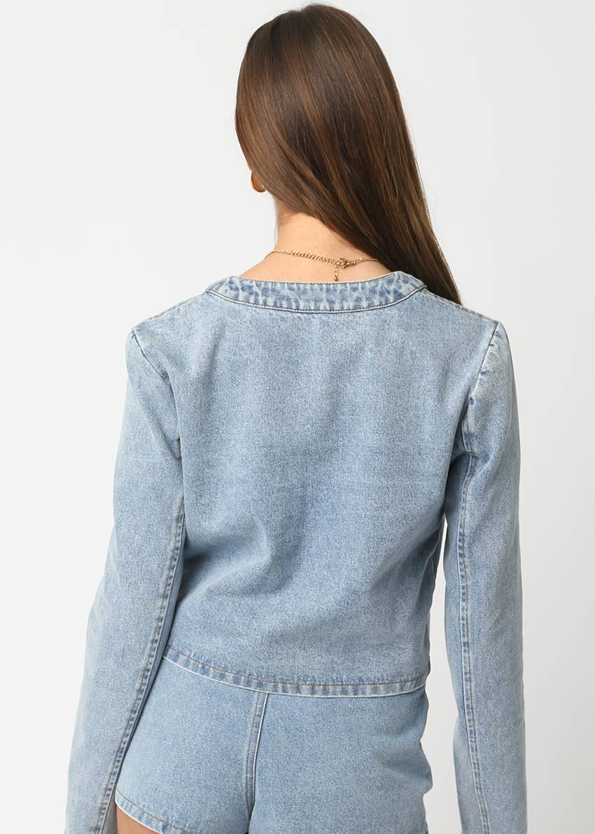 Light blue denim jacket worn by a person on a white background