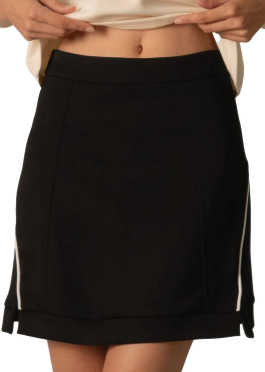 Black skirt with white trim worn by a person on a neutral background