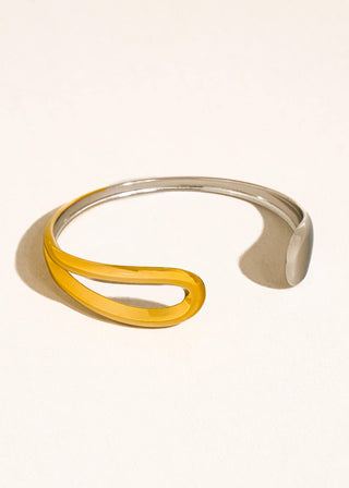 Silver and gold bracelet on a light beige background