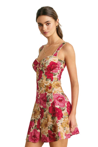 Woman wearing a floral dress against a white wall