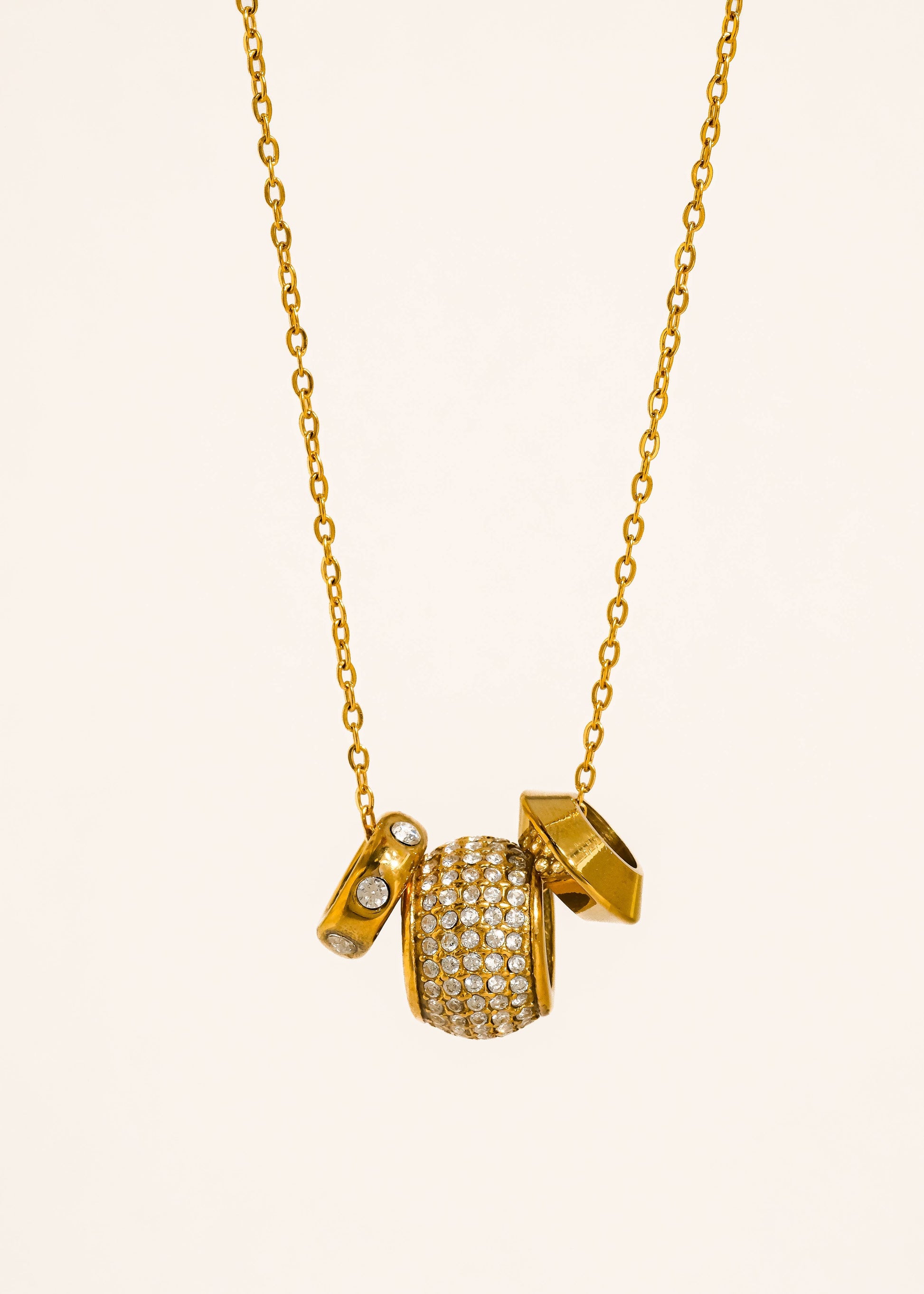 Gold necklace with a unique pendant on a white background