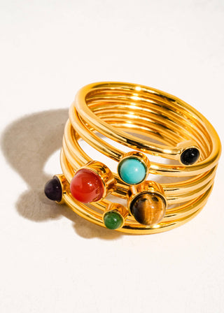 Gold ring with multicolored gemstones on a white background