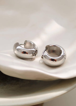 A pair of small classic hoop earrings made of 18K gold-plated stainless steel, displayed on a white surface.