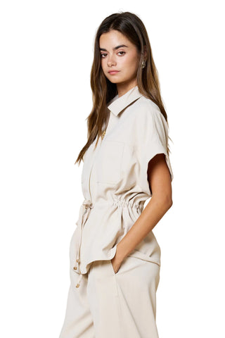 Woman wearing a beige outfit against a beige background