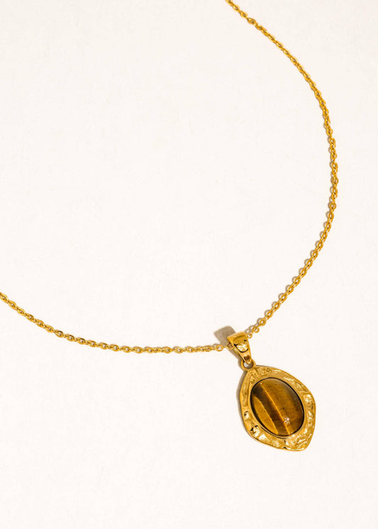 Gold necklace with a tiger's eye pendant on a white background