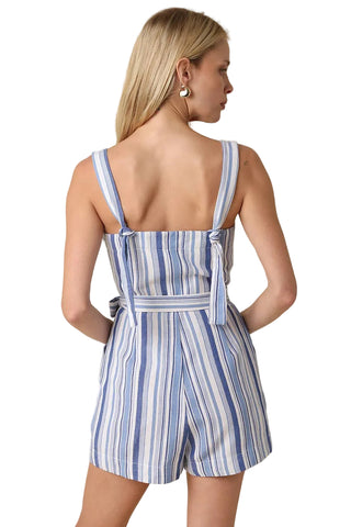 Woman wearing a blue and white striped romper on a beige background