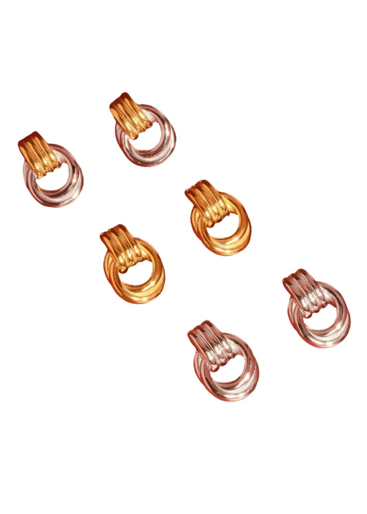 Gold and silver earring clips on a red background