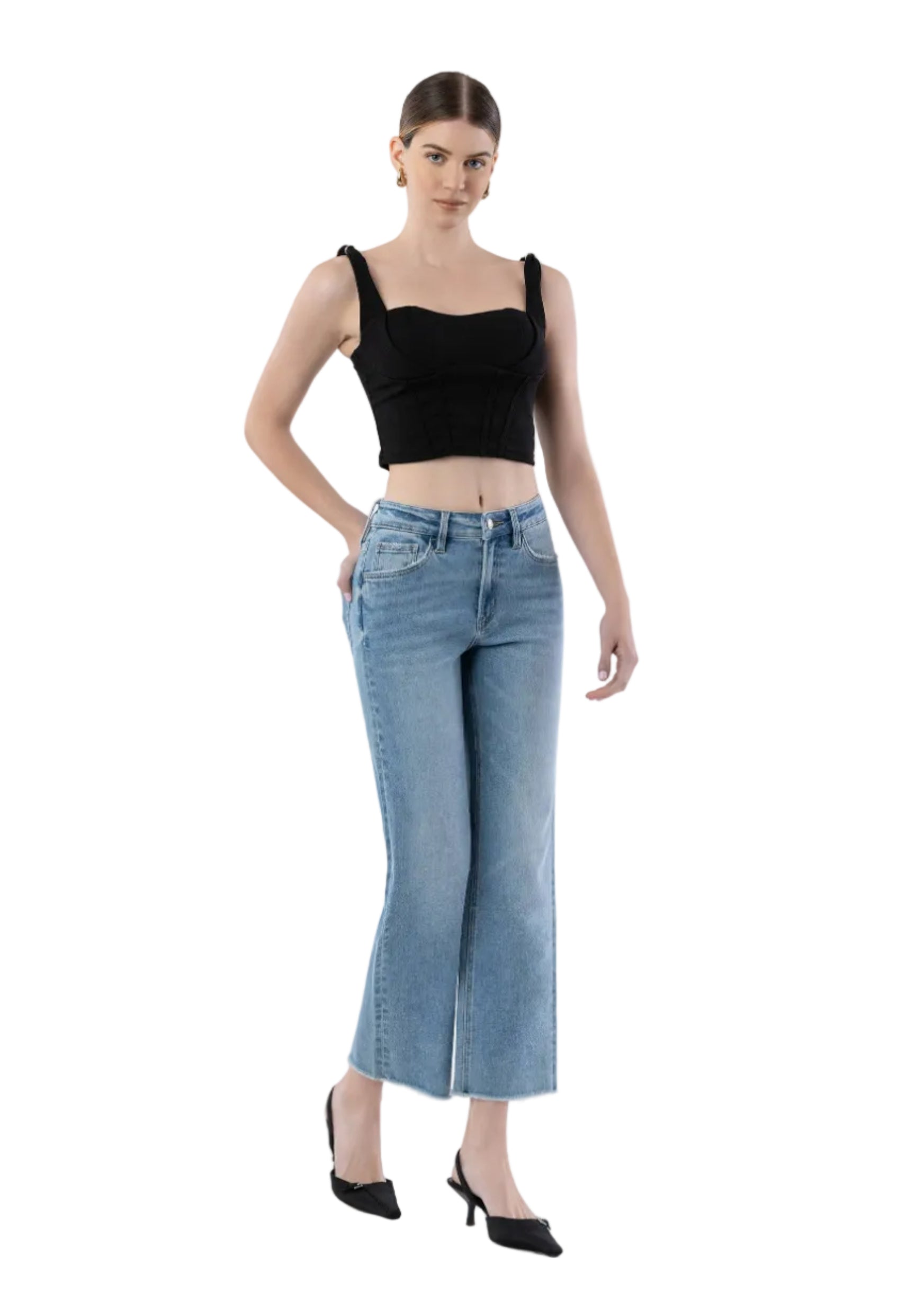 Woman wearing a black crop top and light blue jeans on a white background