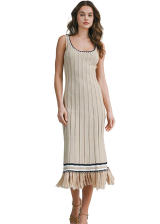Woman wearing a beige dress with black trim on a gray background