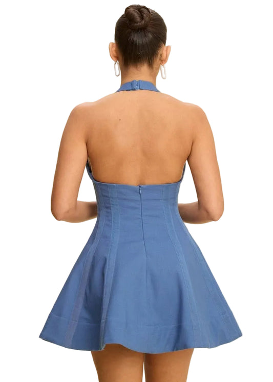 Woman wearing a blue mini fit and flare dress with a beige background