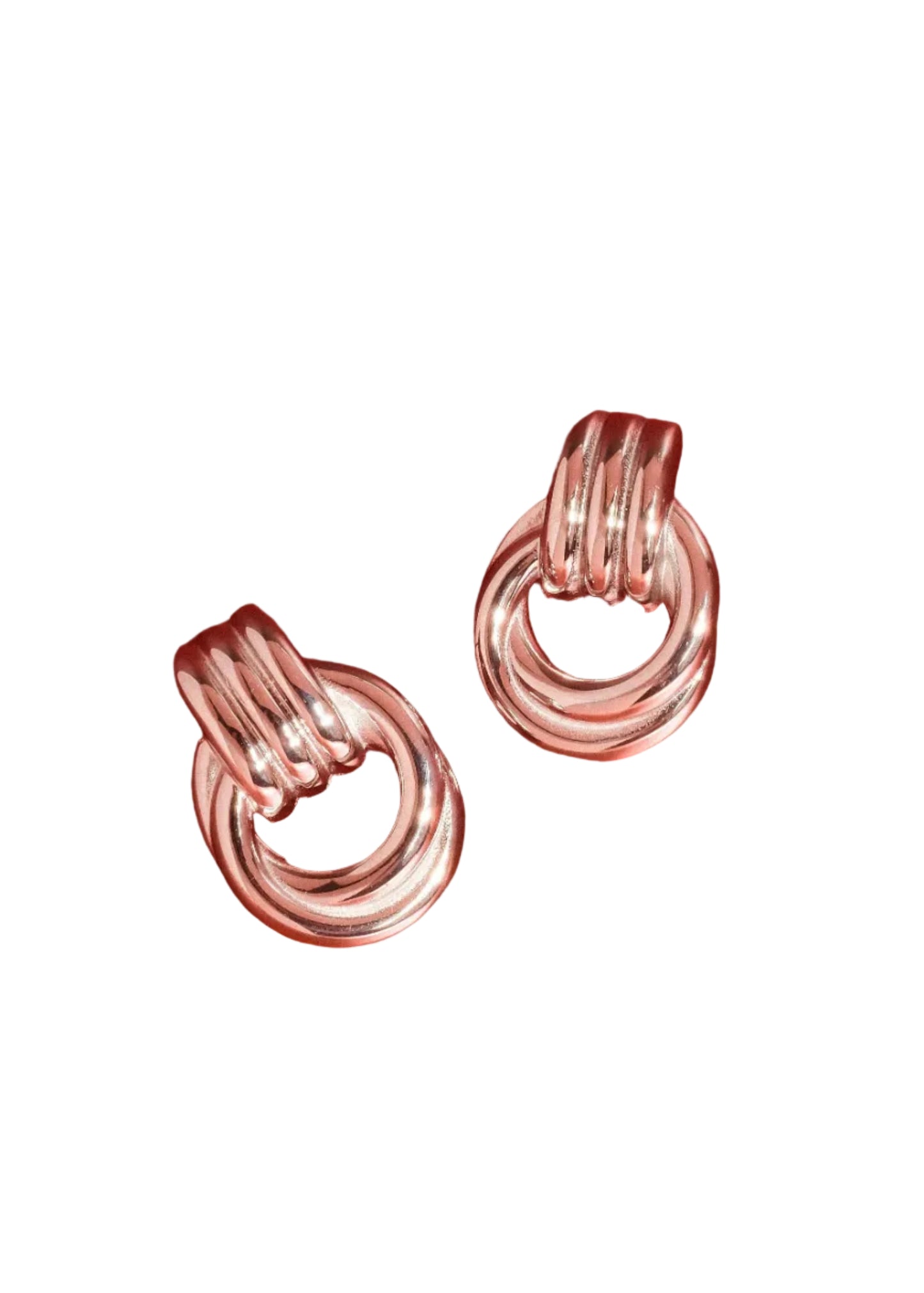 Pair of silver hoop earrings on a red background