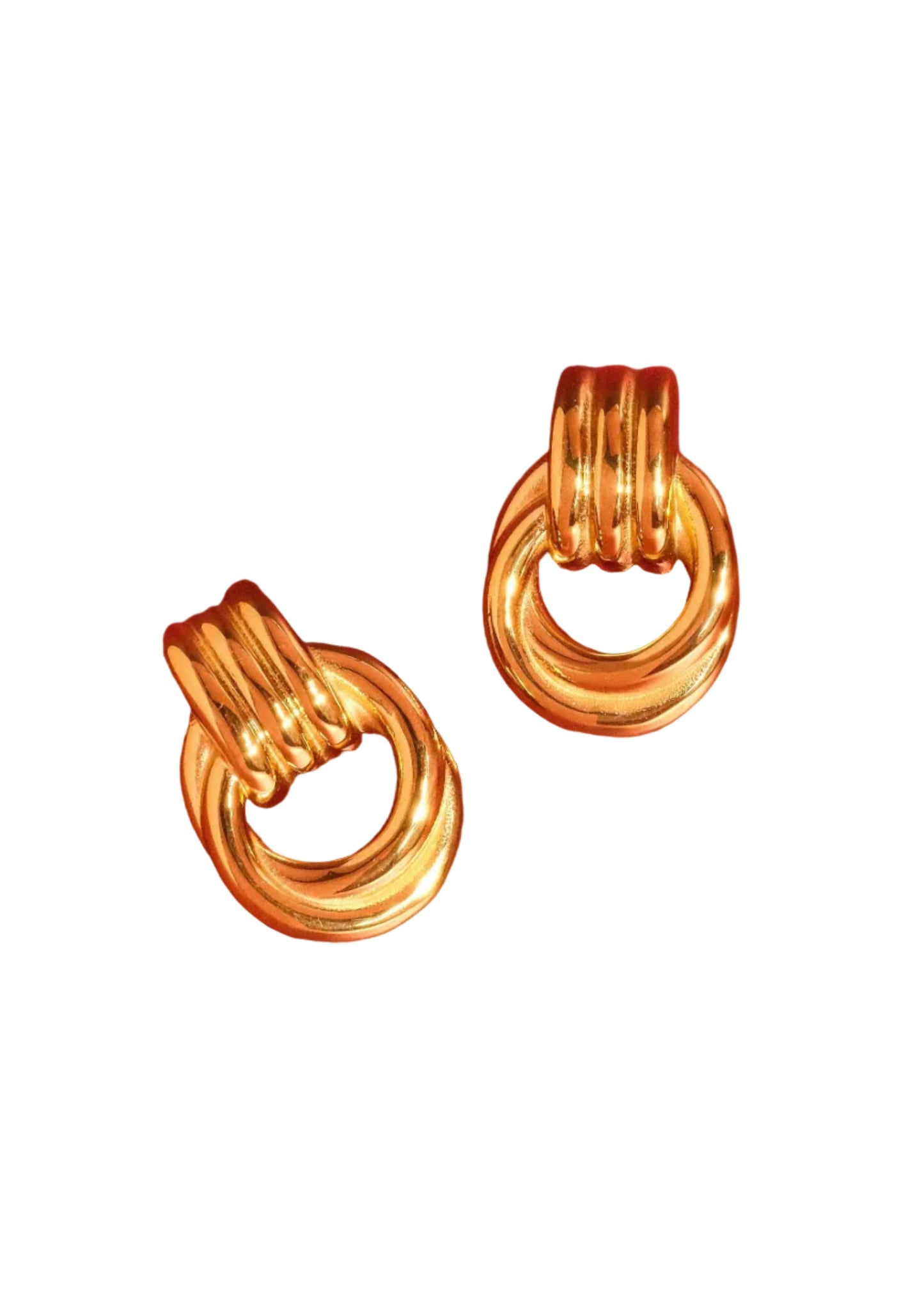 Pair of gold hoop earrings on a red background