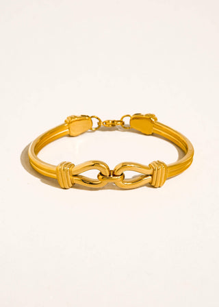 Gold bracelet on a beige background