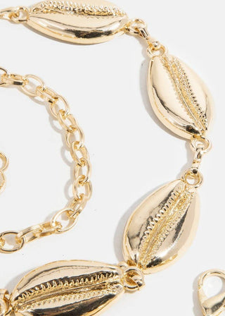 Gold bracelet with shell-like and chain links on a white background