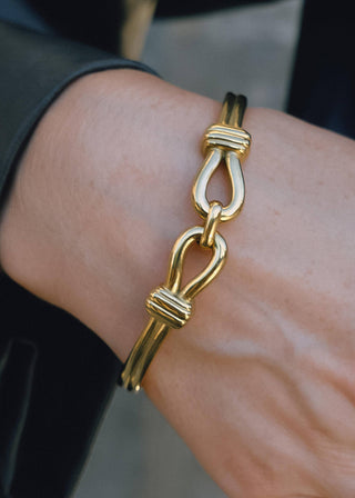 Gold bracelet on a wrist with a blurred background