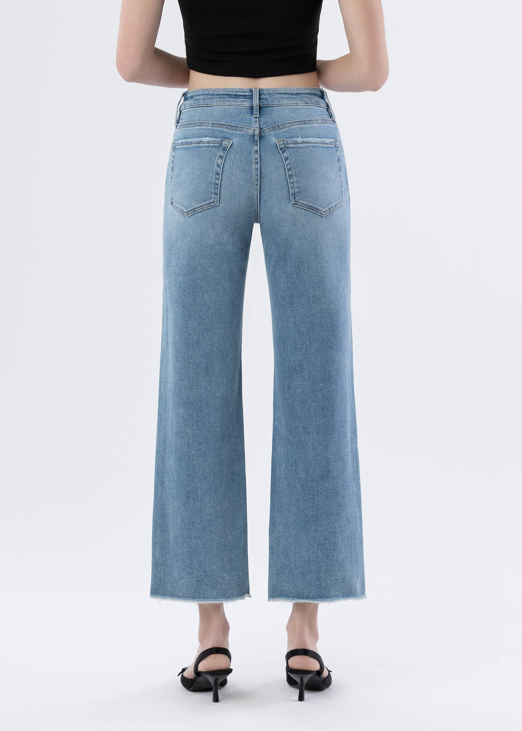 Person wearing light blue jeans on a white background