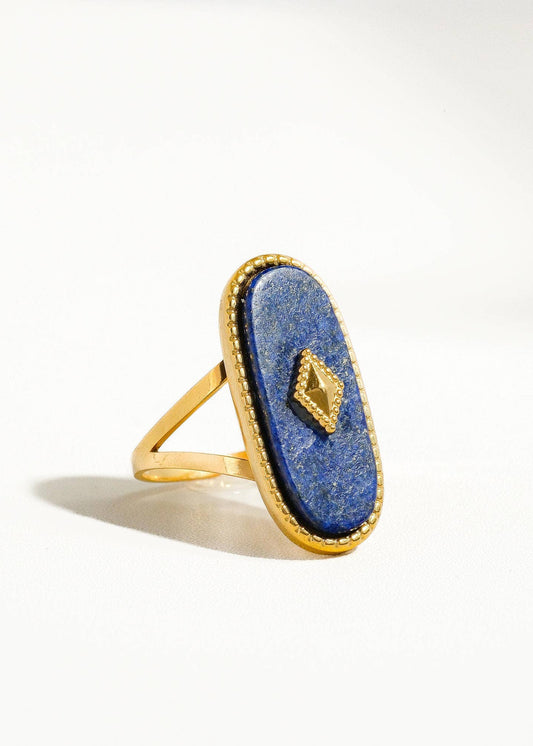 Gold ring with a blue stone on a white background