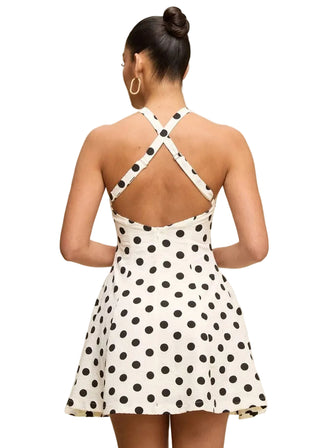 Woman wearing a polka dot dress with a beige background
