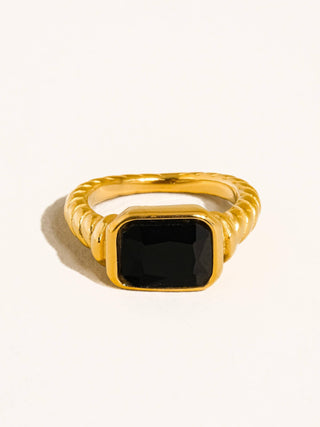 Gold ring with a black gemstone on a white background