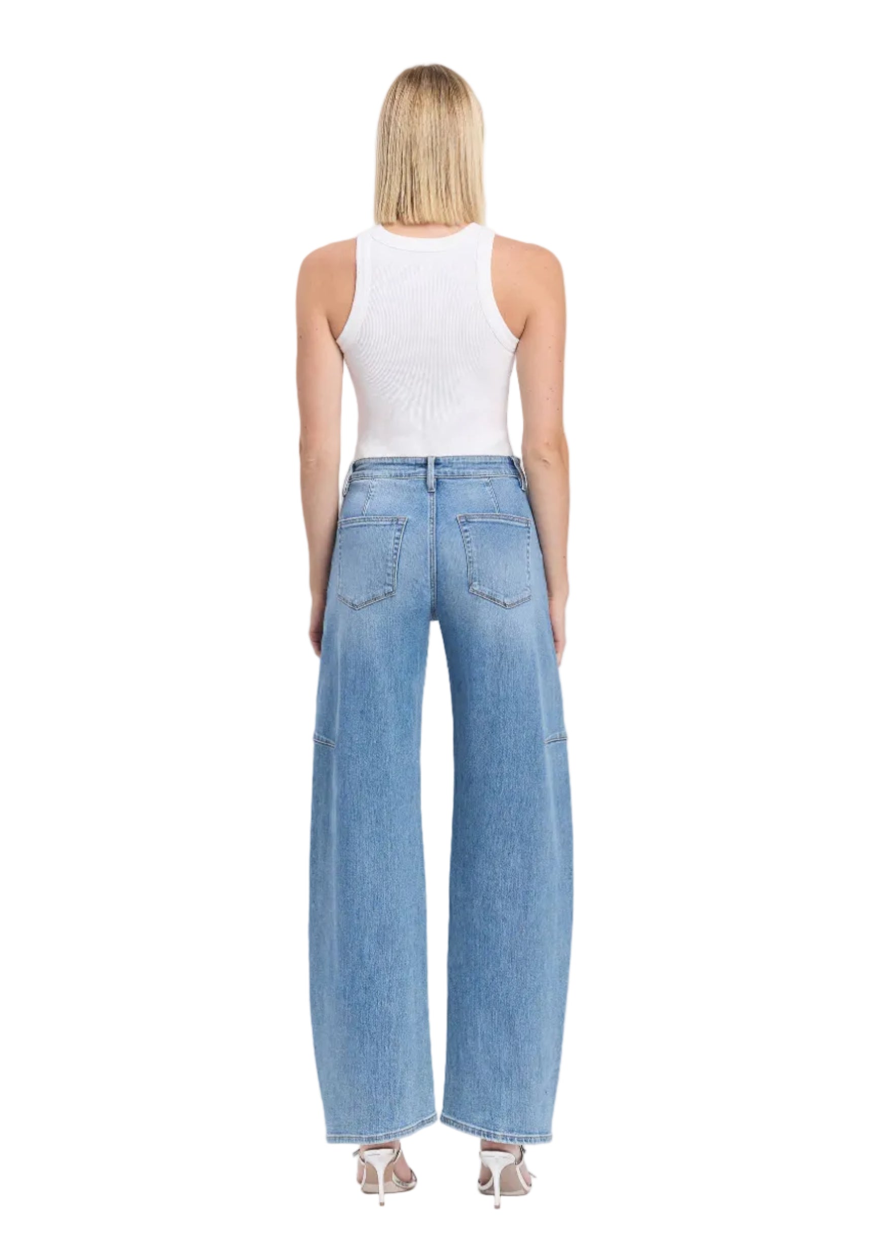 Woman wearing light blue jeans and a white top on a white background