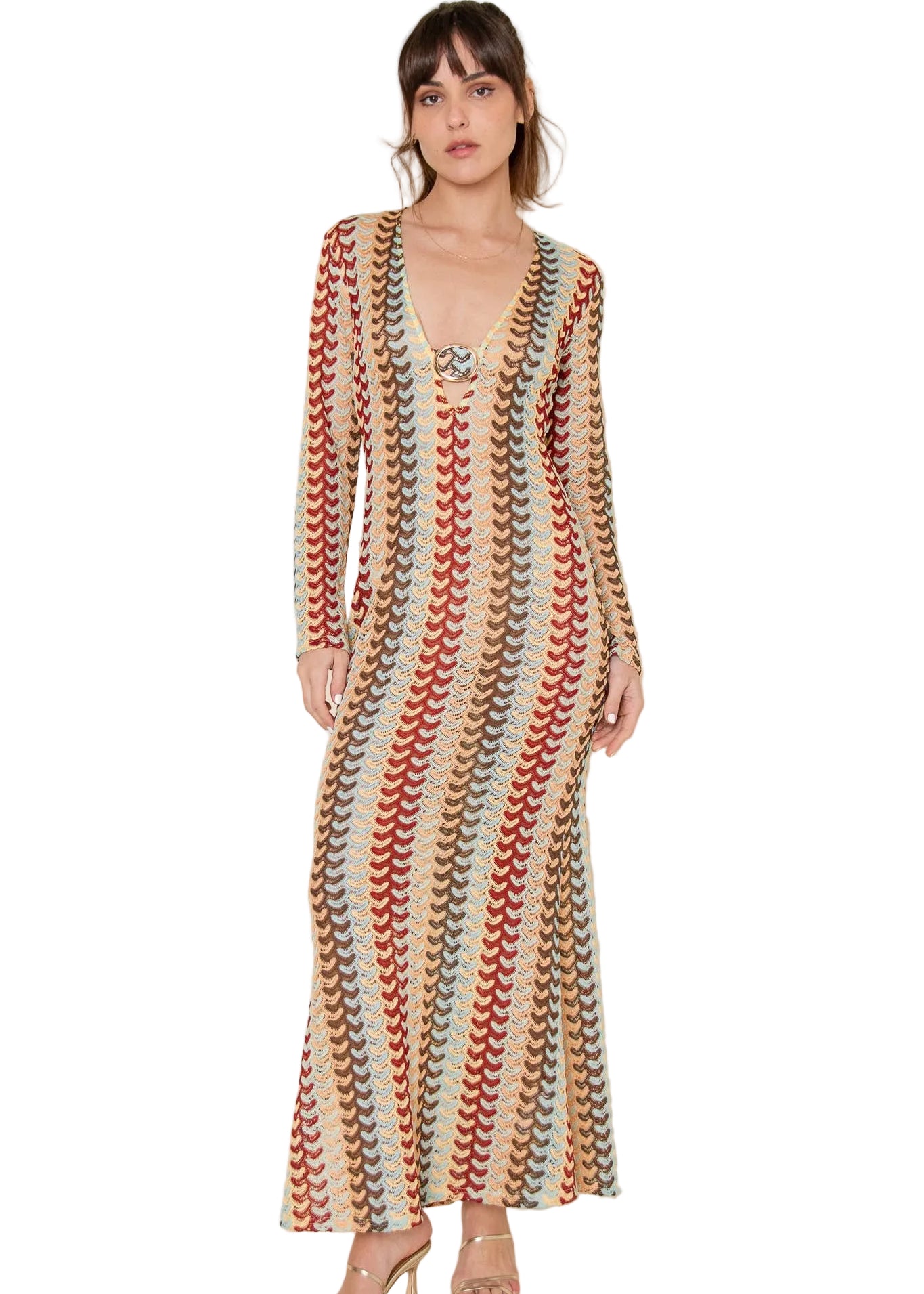 Woman wearing a long, patterned coverup dress against a plain background