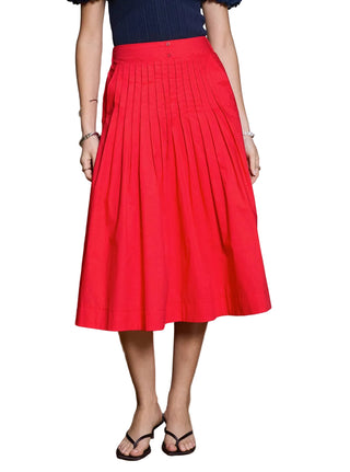 Person wearing a red pleated skirt with a neutral background