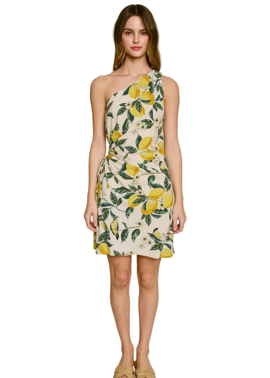 Woman wearing a one-shoulder dress with lemon print on a white background