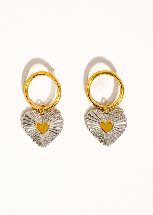 Pair of earrings with heart-shaped charms on a white background