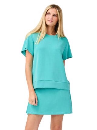 Woman wearing a turquoise dress against a white background