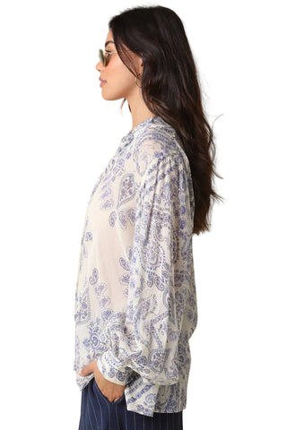 Woman wearing a floral blouse against a beige background