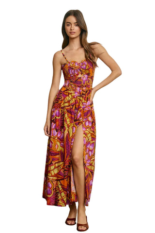 Woman wearing a colorful floral dress against a plain background