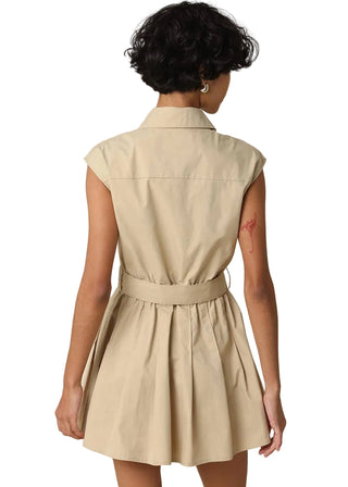 Woman wearing a beige sleeveless dress against a beige background