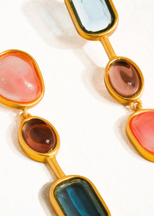 Multicolored gemstone necklace with gold chain on a white background