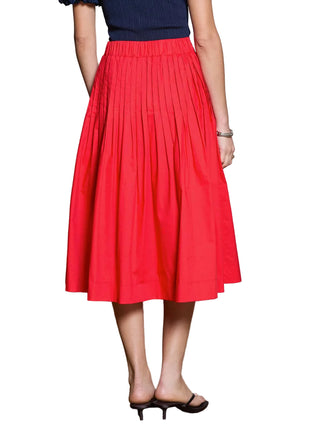 Person wearing a red pleated skirt with a neutral background